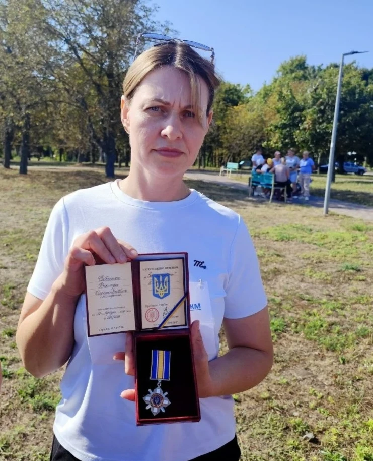 Сестра полеглого захисника Віктора Савченка Валентина Болотіна тримає в руках нагороду брата