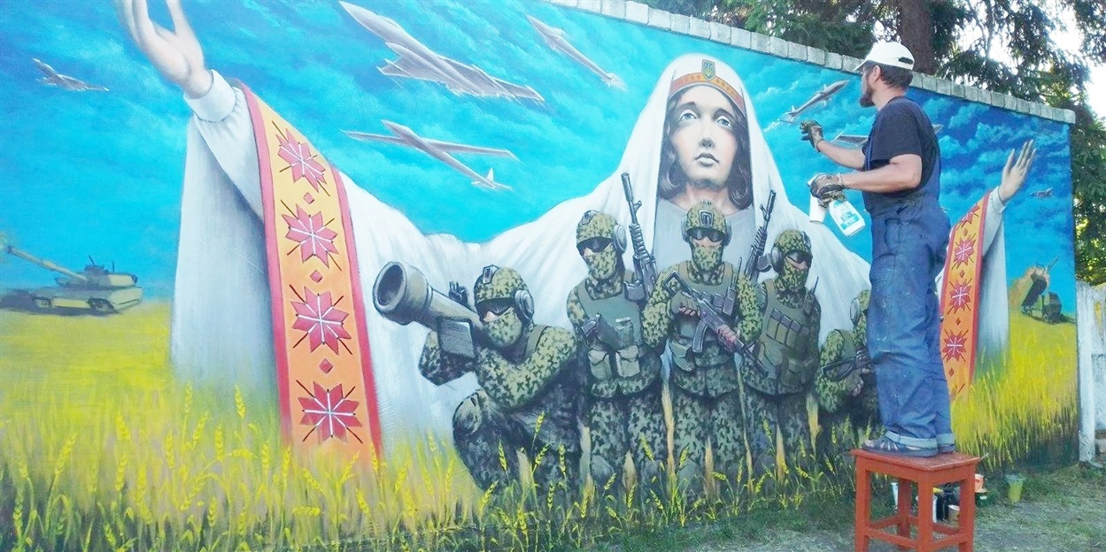 Художник Володимир Поляков під час сворення муралу