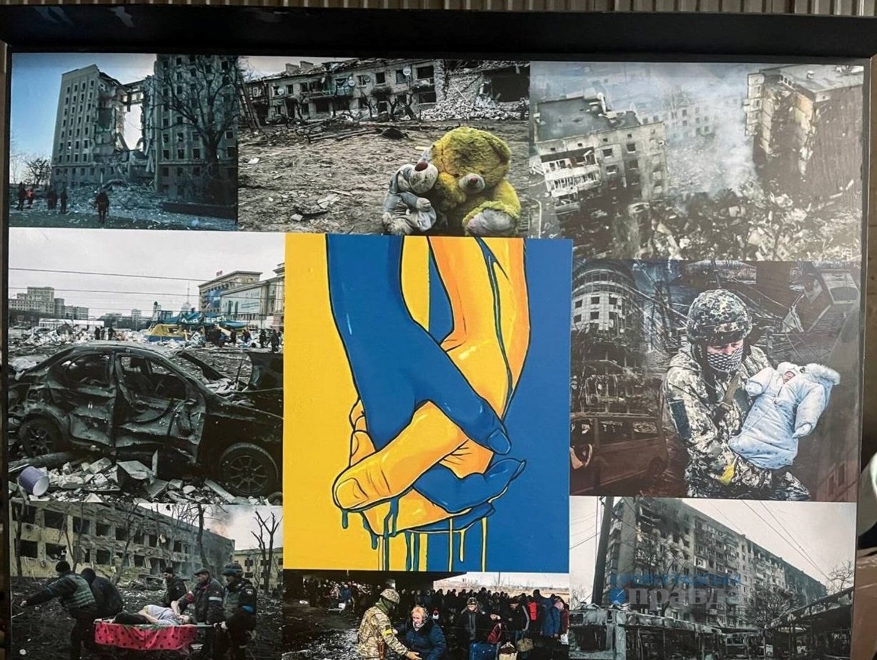 Стенд зі світлинами українських міст після російських атак.