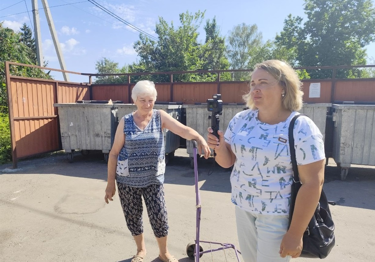 Журналістка Олена Тригубенко проводить опитування  мешканців біля майданчика для збору сміття у Знам'янці