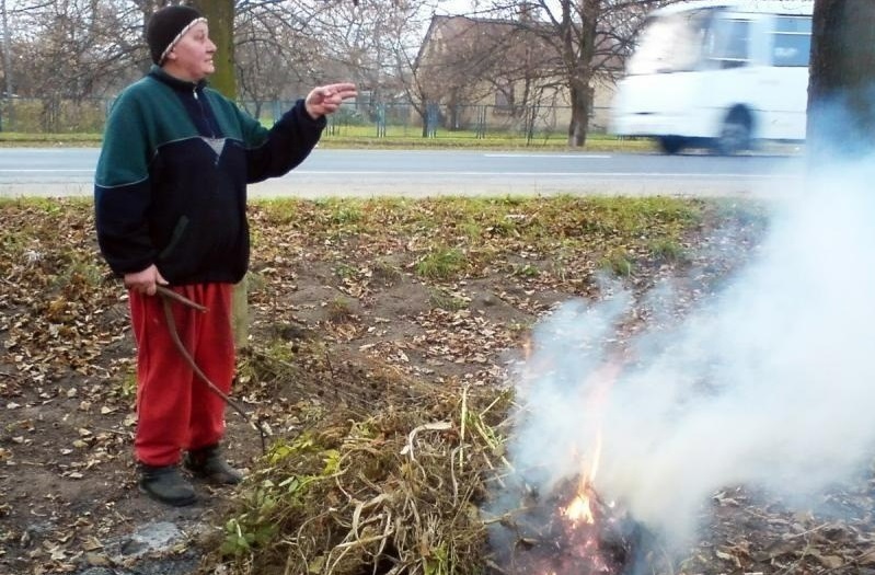Жінка спалює сміття