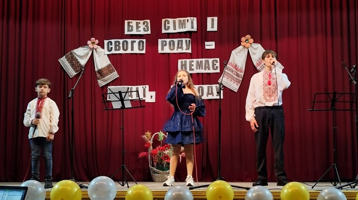 Виконують пісню Андрій, Карина та Дмитро Зіміни