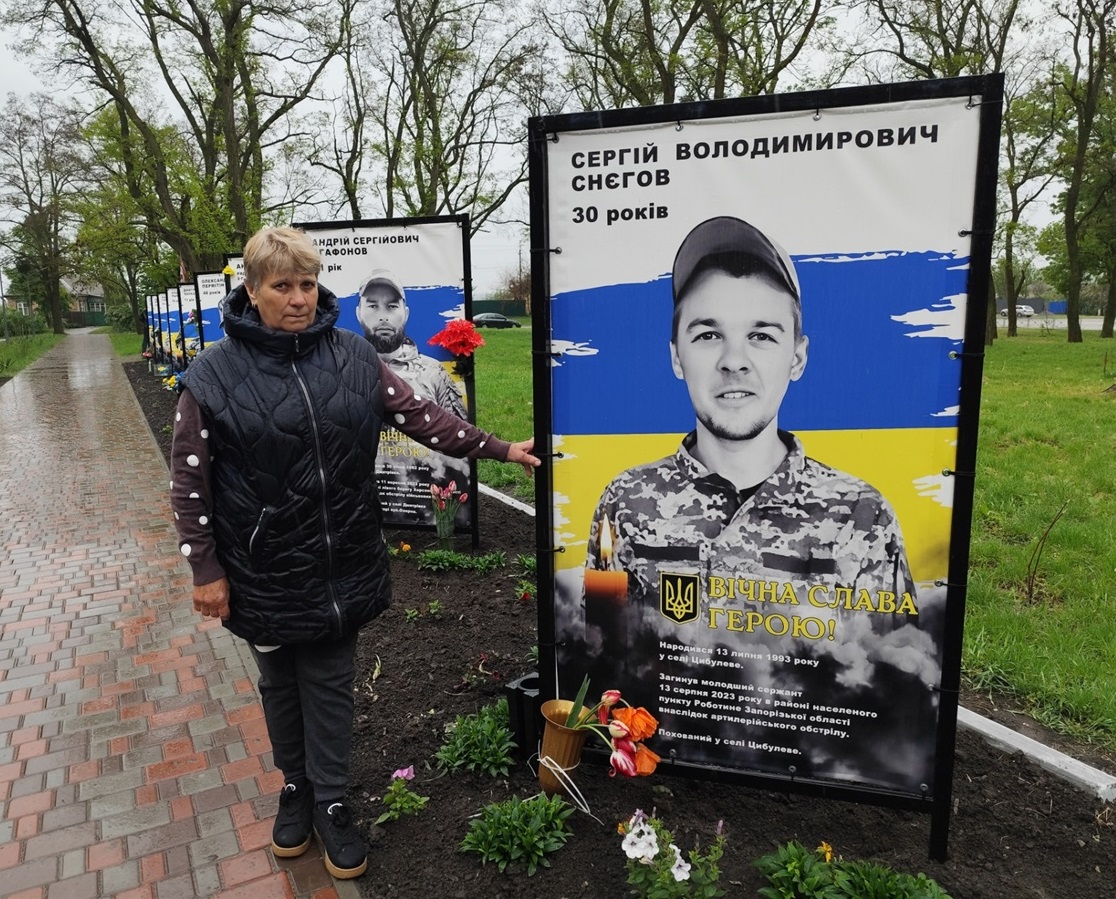 Світлана Снєгова на Алеї пам'яті біля світлини сина