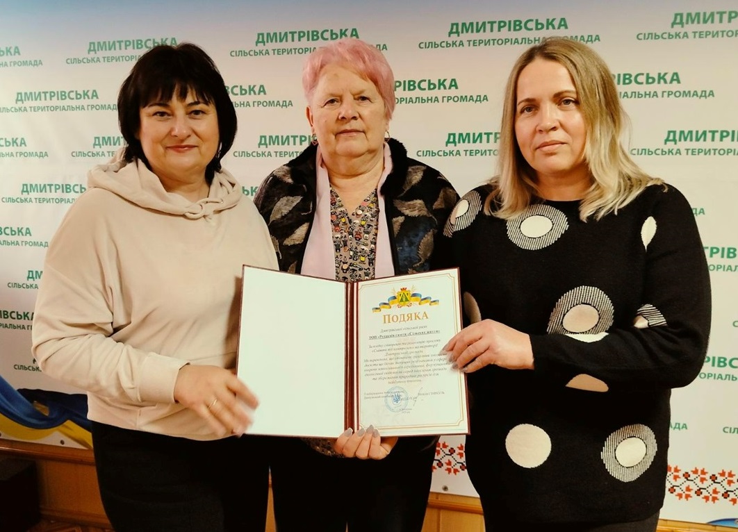 Дмитрівський голова Наталія Стиркуль вручає Подяку журналістам газети "Сільське життя" Катерині Матко та Олені Тригубенко за реалізацію проєкту "Сміття під контролем"