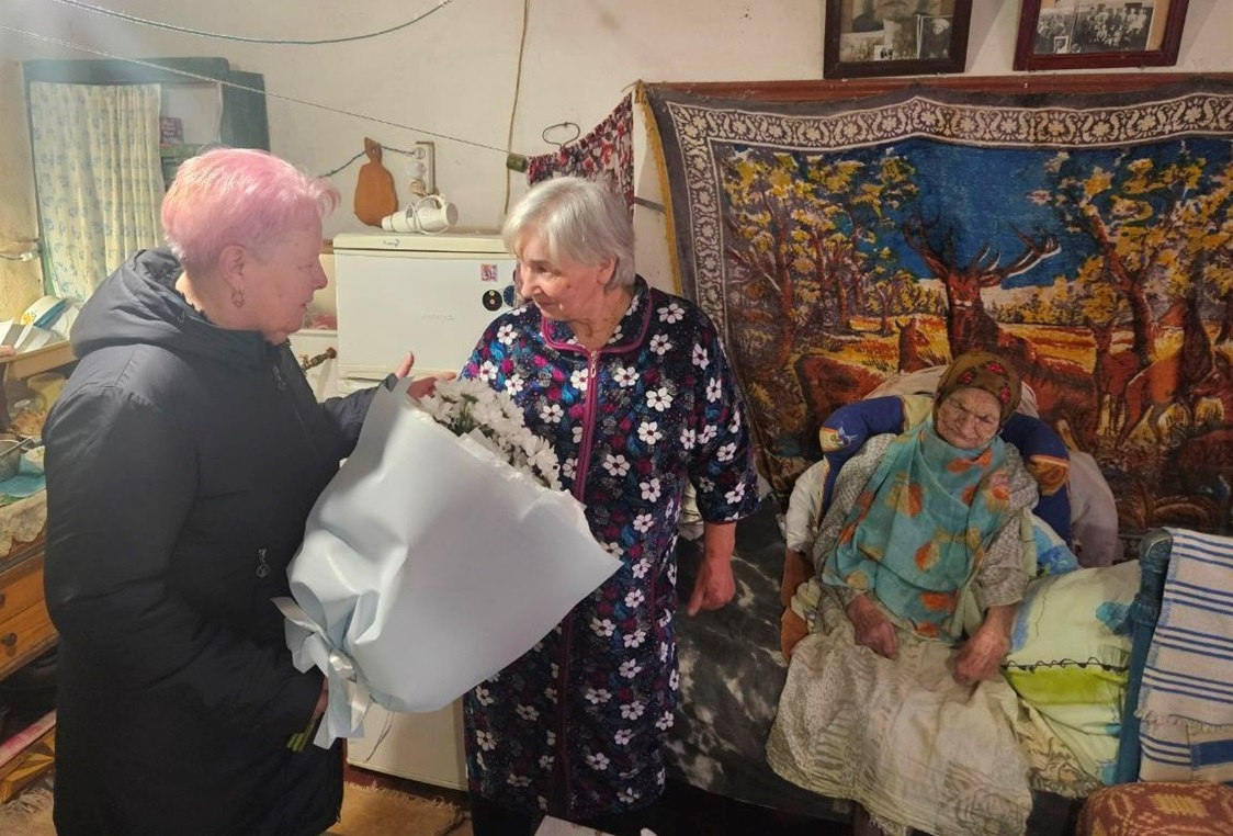 Голова Дмитрівської громади Наталія Стиркуль вітає ювілярку та  вручає квіти її доньці Галині