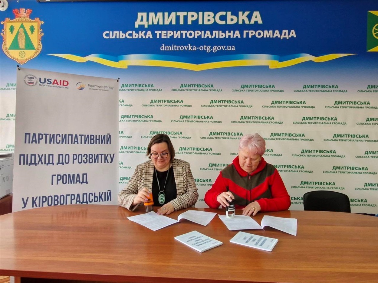 Інга Дуднік та Наталія Стиркуль закріплюють меморандум печатками