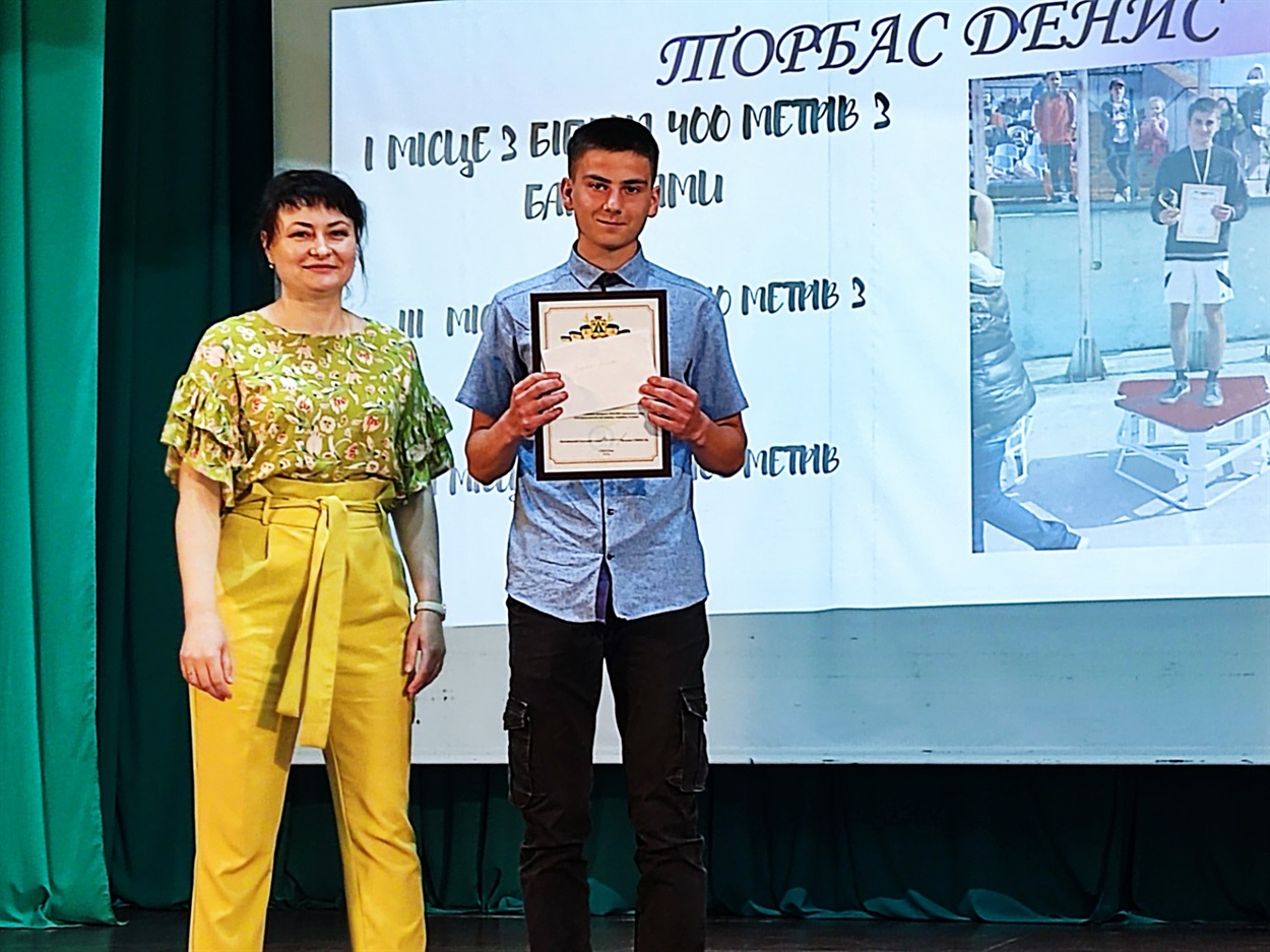 Начальник відділу освіти, молоді та спорту Дмитрівської сільської ради Наталія Бойко нагороджує Дениса Торбаса