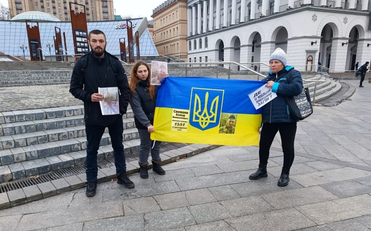 Анастасія з бабусею тримають прапор зі світлиною Віктора Сметани.