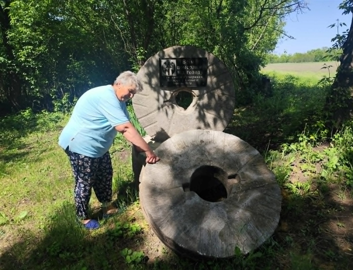 Людмила Підгорна біля пам'ятного знака померлим від голоду у 1932-33роках